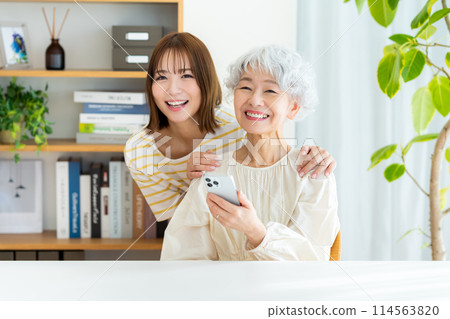 操作智能手機的資深婦女 114563820