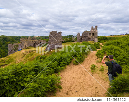 山上一座古老城堡的廢墟和遊客拍攝它（英格蘭威爾士彭納德） 114565222