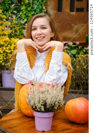 Satisfied woman sitting at a table on the terrace with her chin on her hands Satisfied woman sitting at a table on the terrace with her chin on her hands 114565714