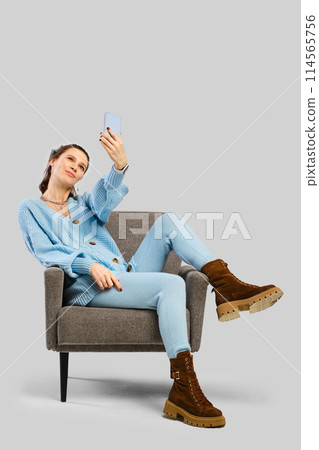 A passionate woman using smartphone on chair A passionate woman using smartphone on chair 114565756