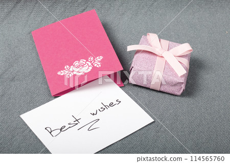 Handmade greeting cards. Near gift in wrapping paper, tied with a ribbon. Original gift. Handmade greeting cards. Near gift in wrapping paper, tied with a ribbon. Original gift. 114565760