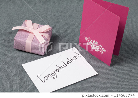 Handmade greeting cards. Near gift in wrapping paper, tied with a ribbon. Original gift. Handmade greeting cards. Near gift in wrapping paper, tied with a ribbon. Original gift. 114565774