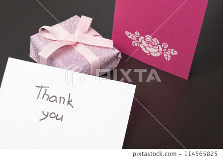 Handmade greeting cards. Near gift in wrapping paper, tied with a ribbon. Original gift. Handmade greeting cards. Near gift in wrapping paper, tied with a ribbon. Original gift. 114565825