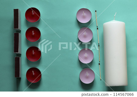 Decorative candles, matchboxes and matches are arranged in a row. On a mint background. Decorative candles, matchboxes and matches are arranged in a row. On a mint background. 114567066