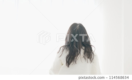 Woman waking up in the morning and looking outside Woman waking up in the morning and looking outside 114568634