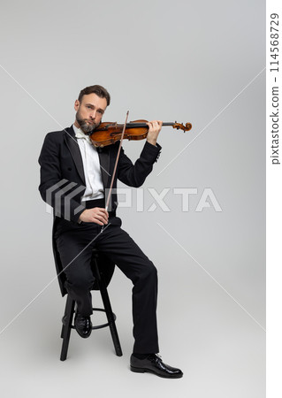 Elegant man skilled musician playing violin Elegant man skilled musician playing violin 114568729