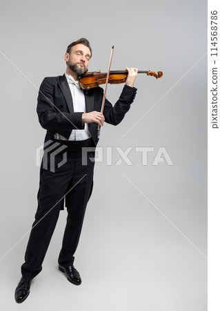 Bearded violinist playing classical music at concert 114568786