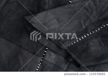 Sleeve detail of a black suede jacket with white contrast stitching Sleeve detail of a black suede jacket with white contrast stitching 114570081