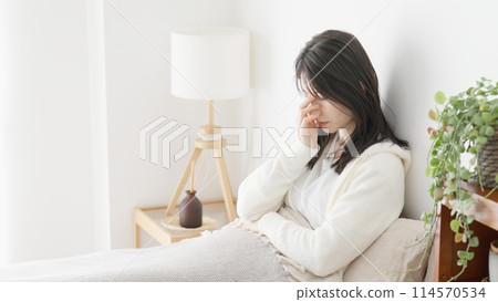 Woman suffering in bed in the morning Woman suffering in bed in the morning 114570534