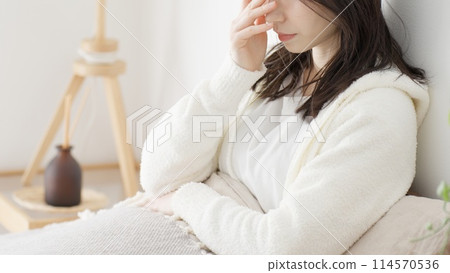 Woman suffering in bed in the morning Woman suffering in bed in the morning 114570536