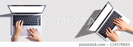 Two people working together with laptop computers 114570683