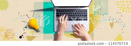 Person using a laptop computer and a light bulb Person using a laptop computer and a light bulb 114570719