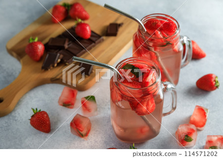 Strawberry diet drink with berries and wooden board with dark chocolate. Fruit drink and healthy concept Strawberry diet drink with berries and wooden board with dark chocolate. Fruit drink and healthy concept 114571202