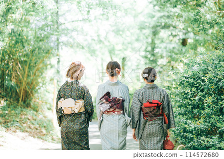 Back view of three women wearing kimonos walking in a landscape of fresh greenery Back view of three women wearing kimonos walking in a landscape of fresh greenery 114572680