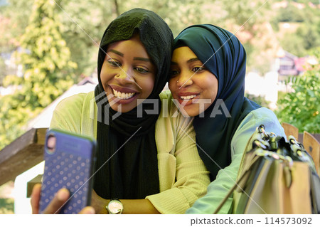 Middle Eastern Muslim Women Capturing Selfies in Serene Surroundings Middle Eastern Muslim Women Capturing Selfies in Serene Surroundings 114573092