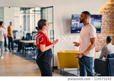 Young business colleagues, including an African American businessman, engage in a conversation about business issues in the hallway of a modern startup coworking center, exemplifying dynamic problem Young business colleagues, including an African American businessman, engage in a conversation about business issues in the hallway of a modern startup coworking center, exemplifying dynamic problem 114573243