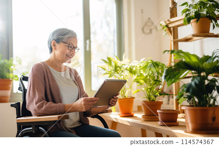 Elderly senior woman with disabilities on wheelchair using tablet, wellness at home concept Elderly senior woman with disabilities on wheelchair using tablet, wellness at home concept 114574367