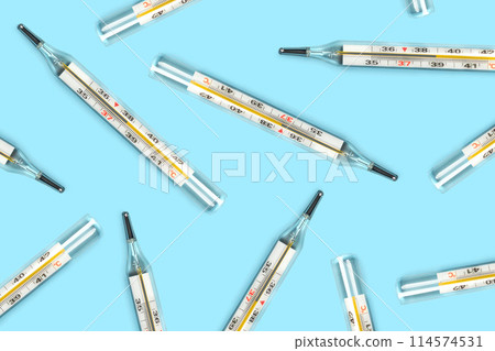 Mercury-in-glass thermometer creative pattern on blue background flat lay healthcare, treatment concept Mercury-in-glass thermometer creative pattern on blue background flat lay healthcare, treatment concept 114574531