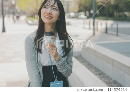 A young working woman holding a takeaway paper cup 114574914