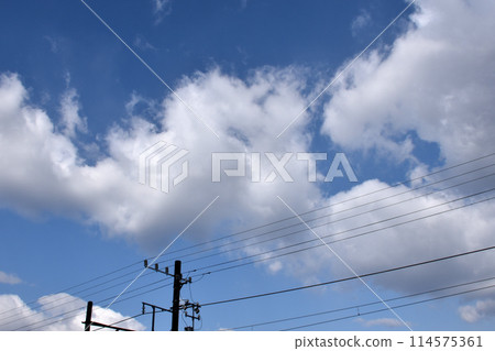 White clouds floating above a telephone pole 114575361