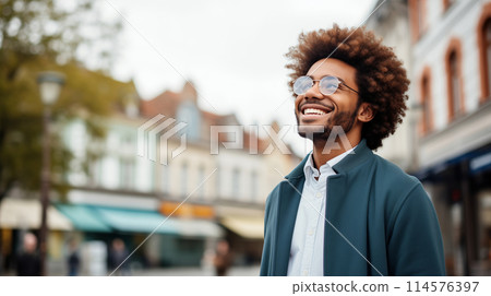 Confident happy smiling black entrepreneur standing in the city, wearing glasses and looking away 114576397