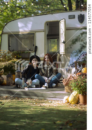 A duo of chic ladies flaunt their bohemian flair in front of the trailer. A duo of chic ladies flaunt their bohemian flair in front of the trailer. 114577054