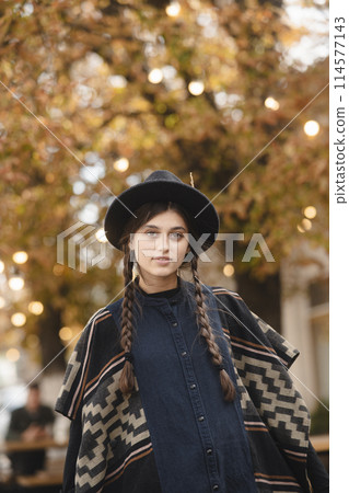 A fashionable young woman dressed elegantly in black with a hat. A fashionable young woman dressed elegantly in black with a hat. 114577143