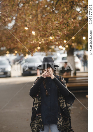 A lovely lady adorned in black clothing and a stylish hat. A lovely lady adorned in black clothing and a stylish hat. 114577161