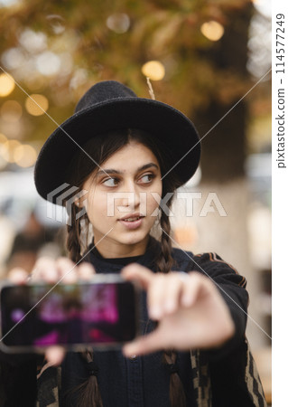 An elegant and stylish lady, accessorized with a black hat and a braided hairstyle. An elegant and stylish lady, accessorized with a black hat and a braided hairstyle. 114577249