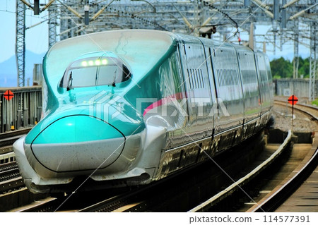 A Shinkansen train passing through Nasushiobara Station at high speed 114577391