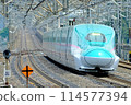 A Shinkansen train passing through Nasushiobara Station at high speed 114577394