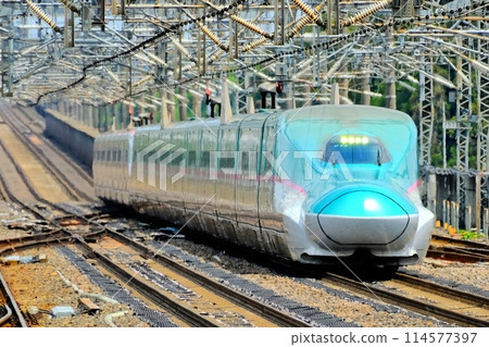 A Shinkansen train passing through Nasushiobara Station at high speed 114577397