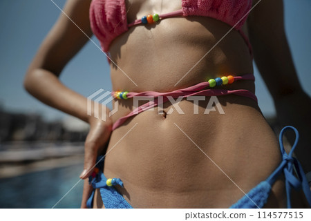 A sporty young woman enjoys the sunshine in her bikini on a sunny day. 114577515