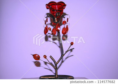 Candlestick in the shape of a flower.With a red bud and decorated with green stones. Candlestick in the shape of a flower.With a red bud and decorated with green stones. 114577682