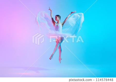 Symphony in motion. Ballet dancer in pirouette, her flowing white dress embodying graceful movements in neon light against vivid background. 114578448