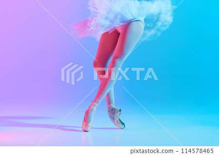 Cropped photo of young, slim ballet dancer in white tutu and pointe in neon light against vivid gradient background. 114578465