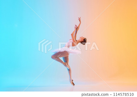 Young ballerina in white tutu dancing and leaning backwards in motion in neon light against blue-orange gradient background. Young ballerina in white tutu dancing and leaning backwards in motion in neon light against blue-orange gradient background. 114578510