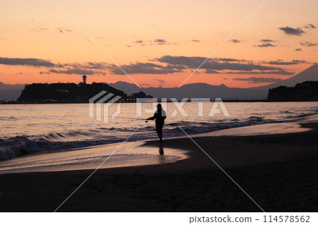 Kamakura: Evening view of the coast of Shichirigahama dyed orange, with the silhouette of Enoshima and Mt. Fuji 114578562