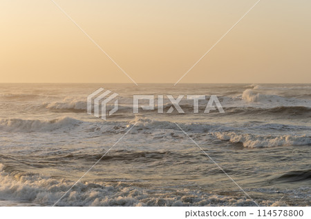 The sea dyed in orange at sunrise The sea dyed in orange at sunrise 114578800