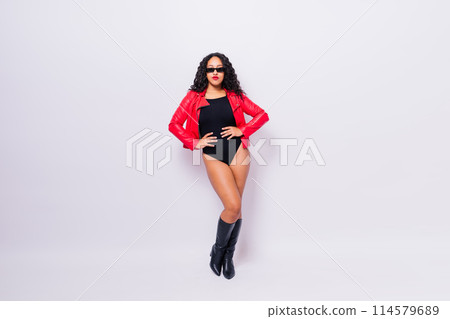 Seductive african woman posing in black bodysuit and jacket in studio. Fit sporty female. 114579689