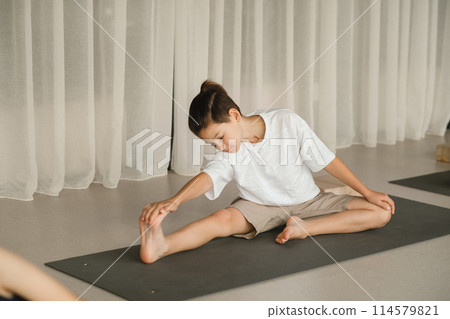 A child does yoga in the gym. Children's gymnastics 114579821