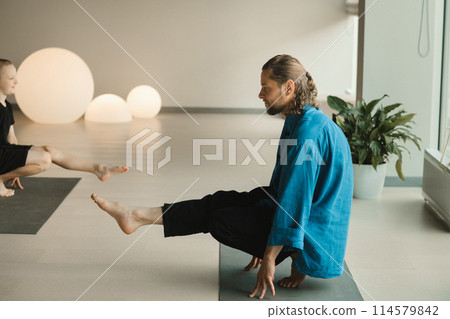 Children do yoga in the gym under the guidance of an instructor. Children's gymnastics 114579842