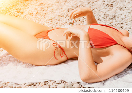 Happy woman taking red bikini off on beach for tan, lady stripping holiday swimsuit with bow in string. Fun, beauty and relax, sexy model untying swimming costume bra, girl in swimwear on vacation Happy woman taking red bikini off on beach for tan, lady stripping holiday swimsuit with bow in string. Fun, beauty and relax, sexy model untying swimming costume bra, girl in swimwear on vacation 114580499
