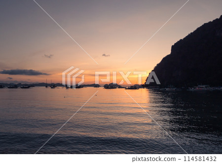 Boats anchored in a calm bay at sunset near scenic islands. Philippines, Palawan. Boats anchored in a calm bay at sunset near scenic islands. Philippines, Palawan. 114581432