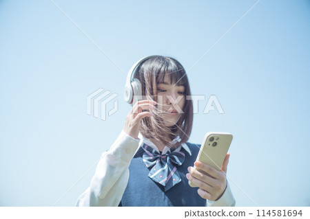 帶耳機和智慧型手機的高中女孩 114581694