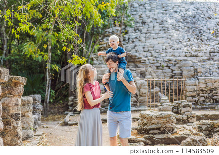 Mom, dad and baby tourists at Coba, Mexico. Ancient mayan city in Mexico. Coba is an archaeological area and a famous landmark of Yucatan Peninsula. Cloudy sky over a pyramid in Mexico 114583509