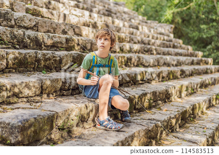 Boy tourist at Coba, Mexico. Ancient mayan city in Mexico. Coba is an archaeological area and a famous landmark of Yucatan Peninsula. Cloudy sky over a pyramid in Mexico Boy tourist at Coba, Mexico. Ancient mayan city in Mexico. Coba is an archaeological area and a famous landmark of Yucatan Peninsula. Cloudy sky over a pyramid in Mexico 114583513