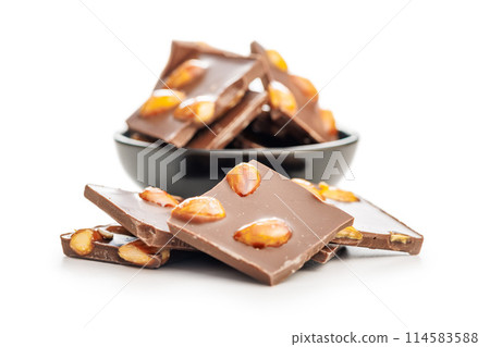Broken chocolate bar with almonds isolated on white background. 114583588