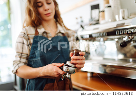 An experienced female bartender prepares a hot drink. Takeaway food. Professional coffee making. 114583618