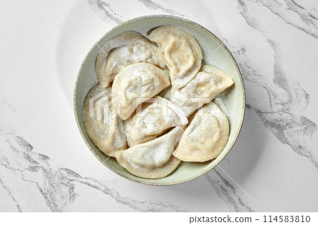 Varenyky with sweet filling sprinkled with powdered sugar Varenyky with sweet filling sprinkled with powdered sugar 114583810